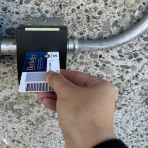 Hand holding a cal 1 card with the side near the UC Berkeley seal on the card reader as if they were inserting it like a credit card